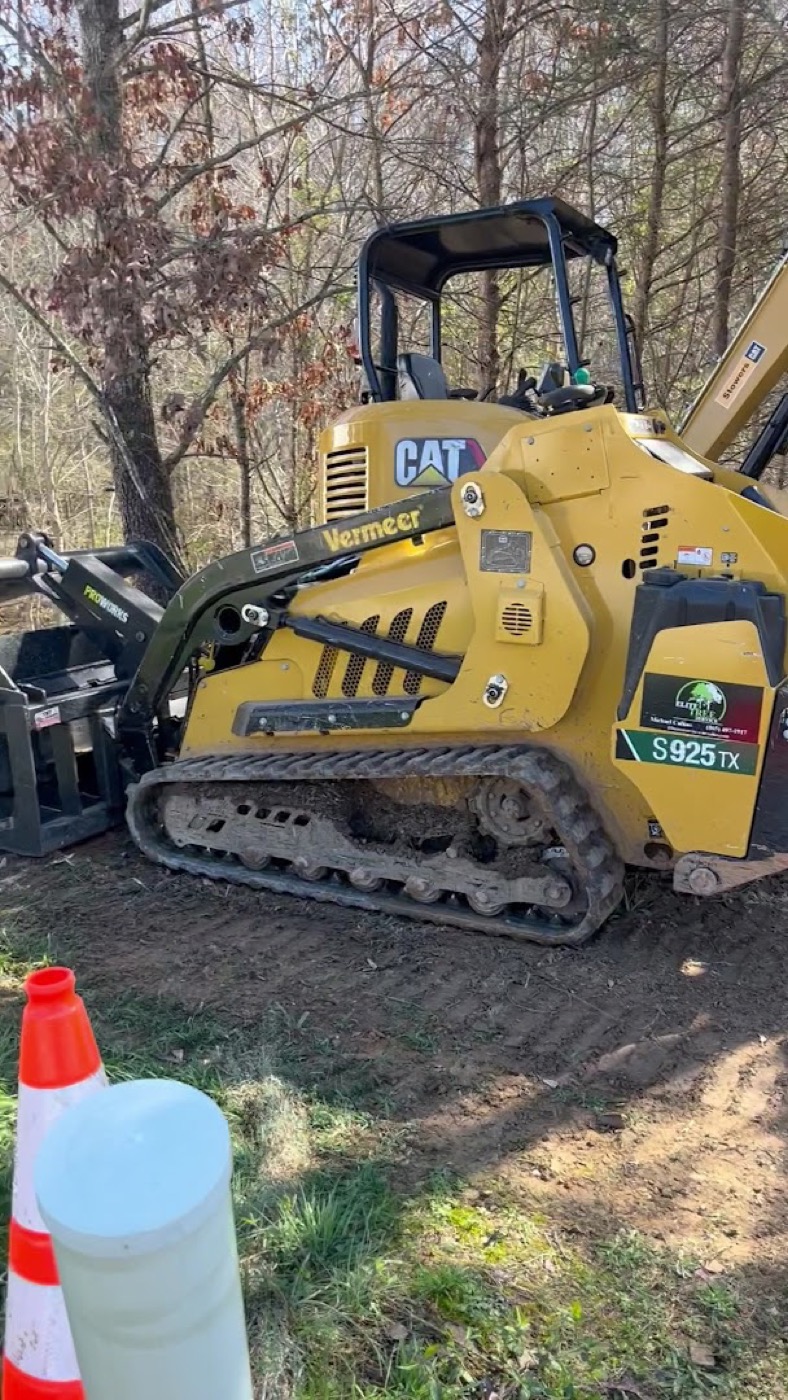 A compact stump grinder clearing a stump on a Powell property